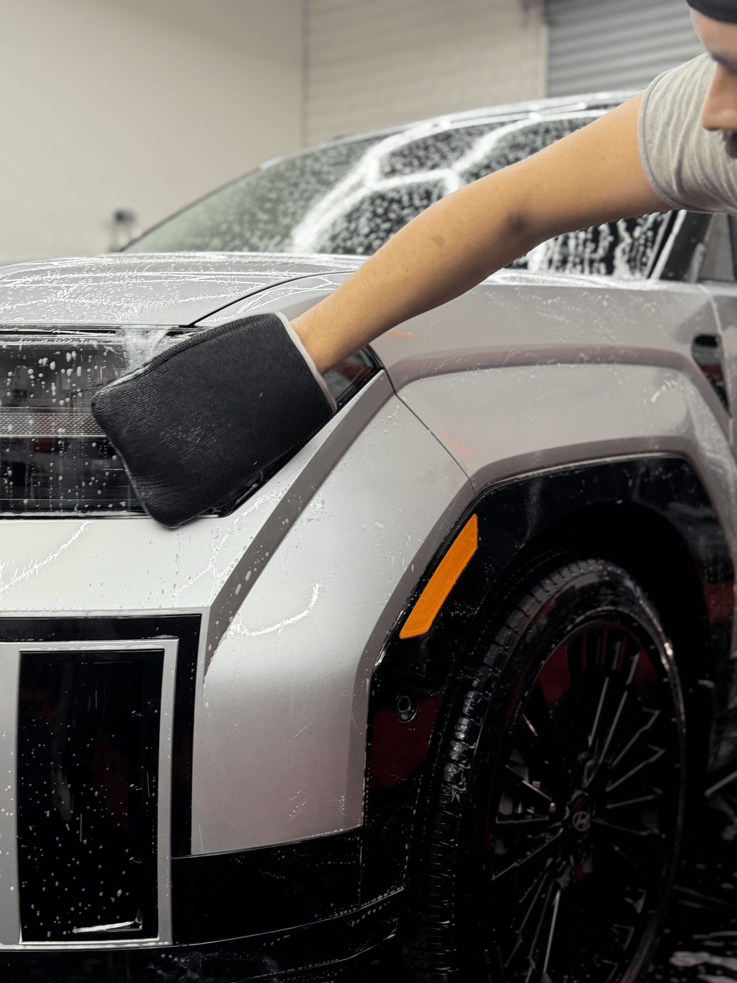 ICON Auto Lab technician foam-washing a silver truck before ceramic coating in the Tucson shop